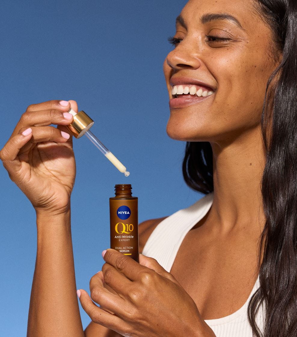 Mujer joven aplicando crema para ojos Nivea Q10