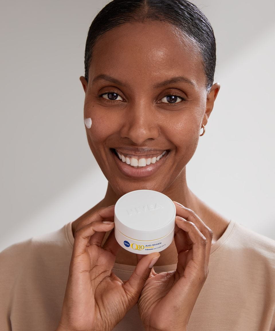 woman holding a Nivea Q10 face cream