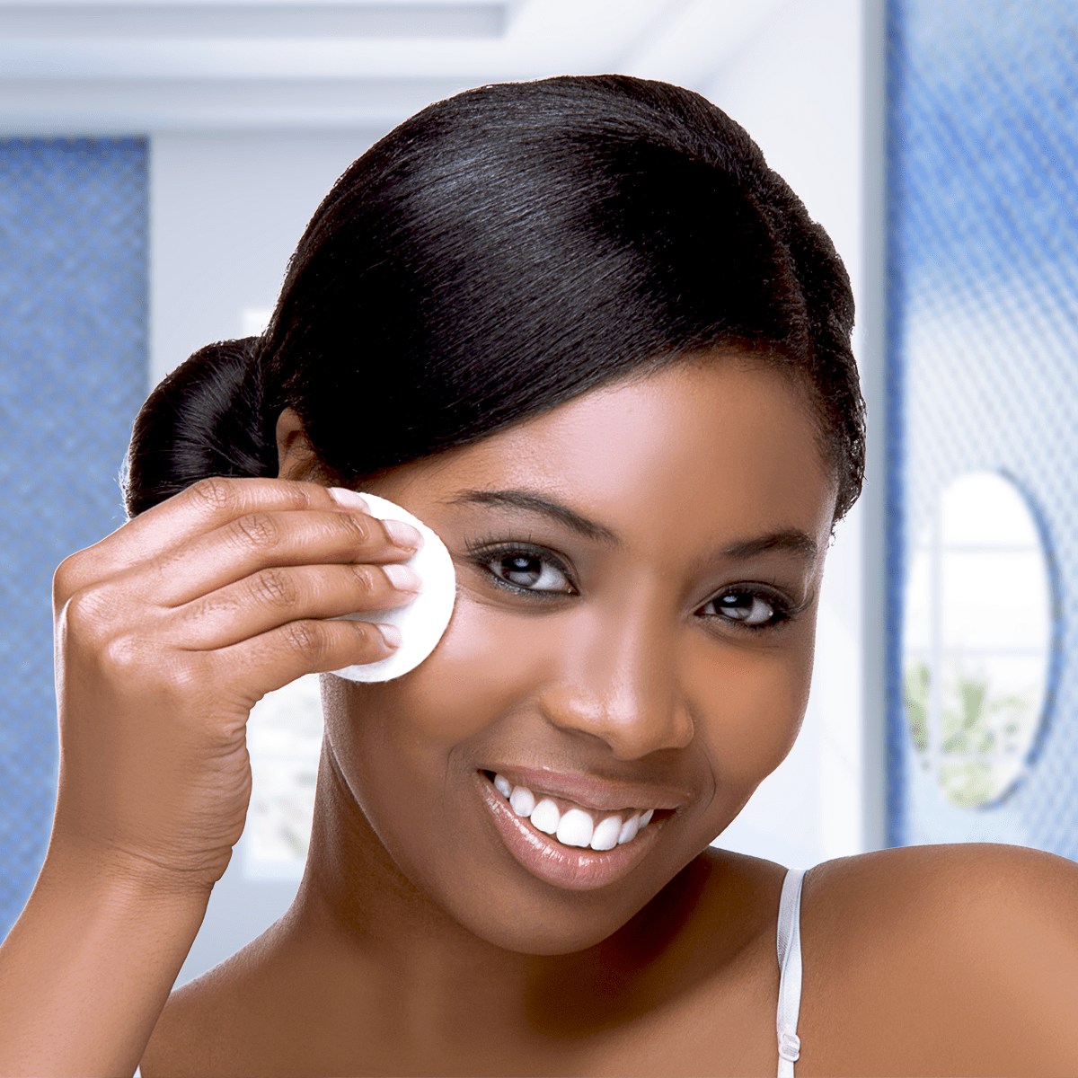 Smiling lady cleaning face with NIVEA Perfect and Radiant Cleansing Foam